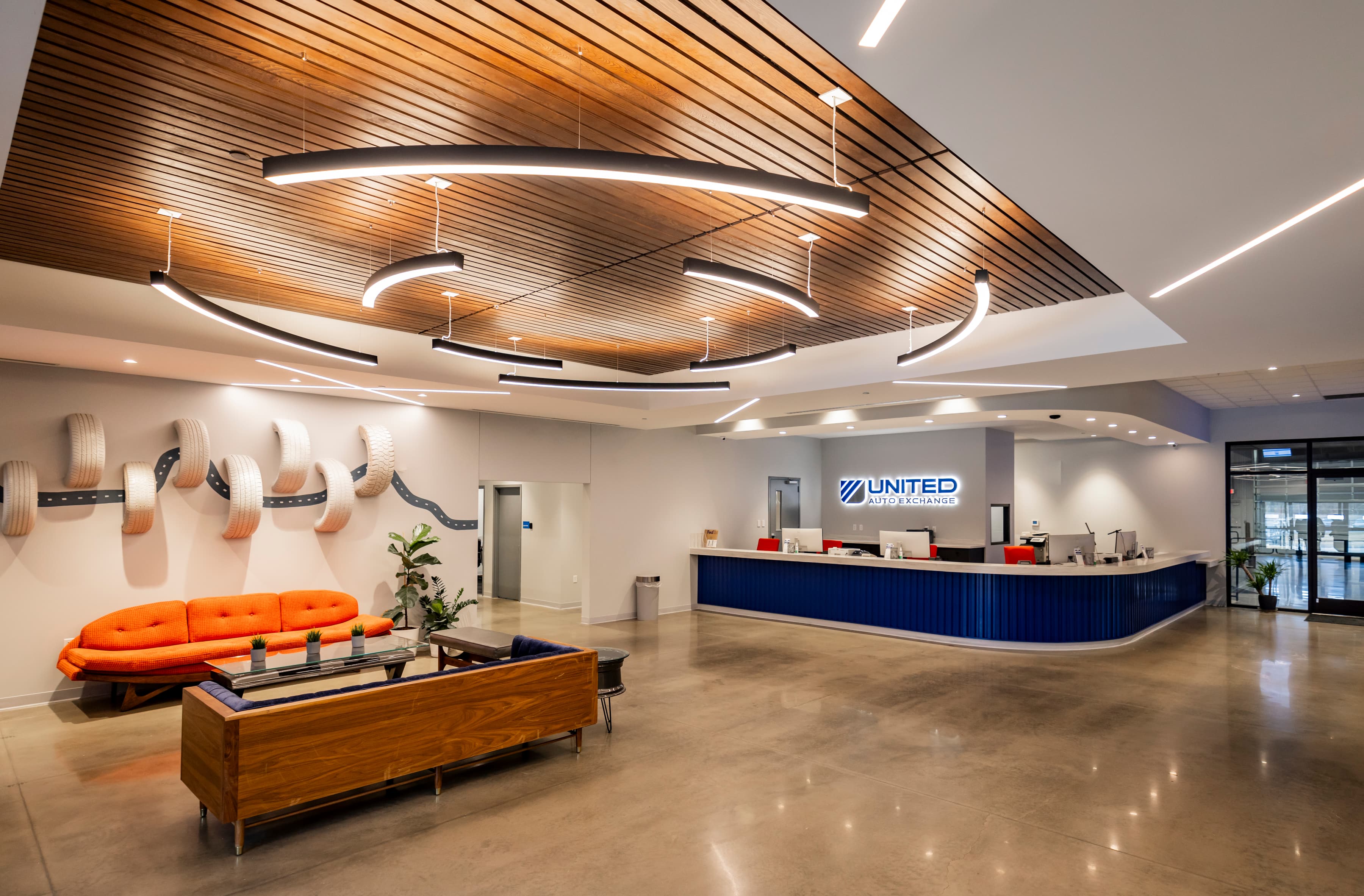 The UAX lobby, wood-rib ceiling, tire wall sculpture, polished concrete