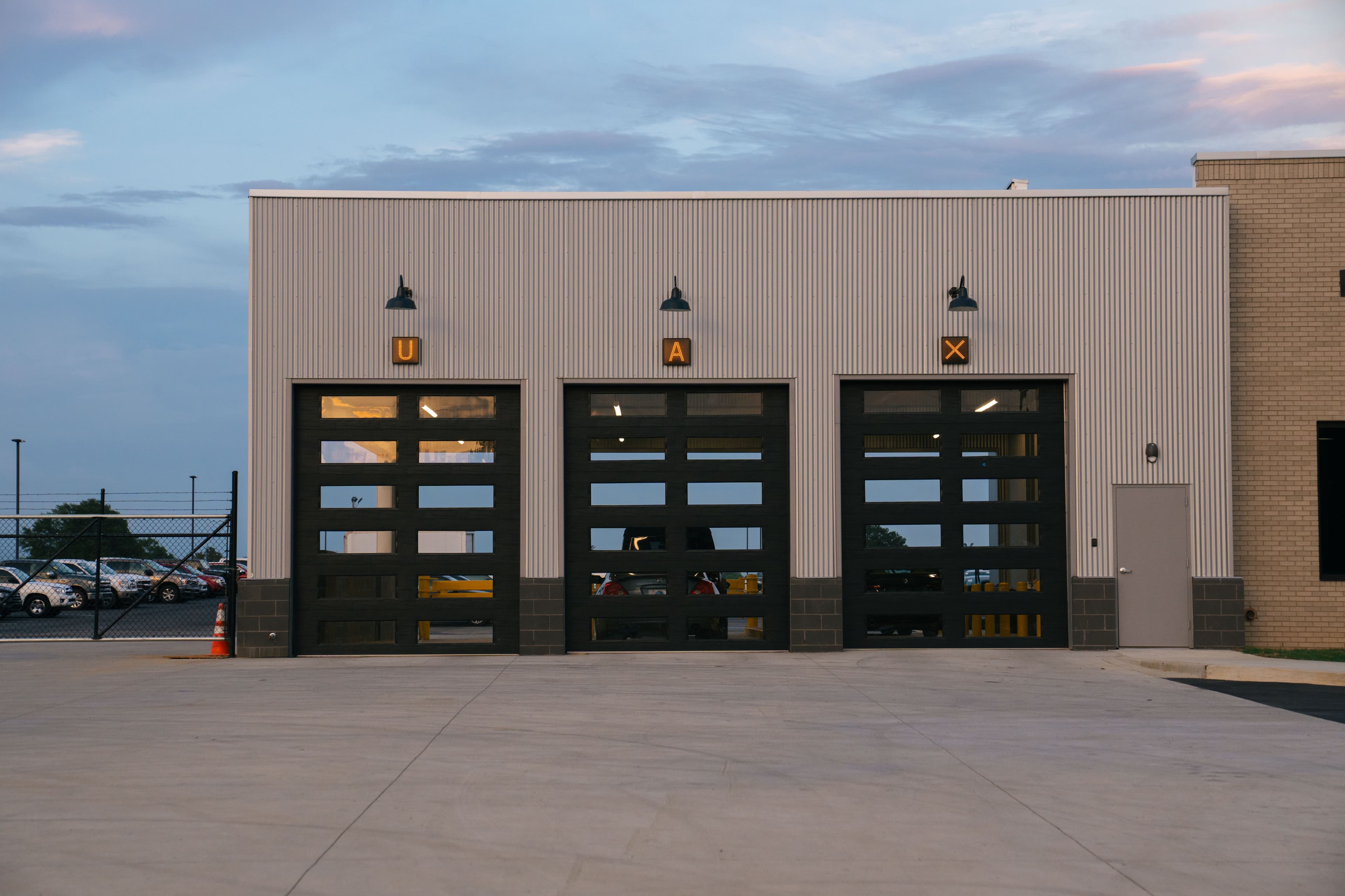 The UAX garage doors, U, A, X letterforms in yellow boxes at dusk